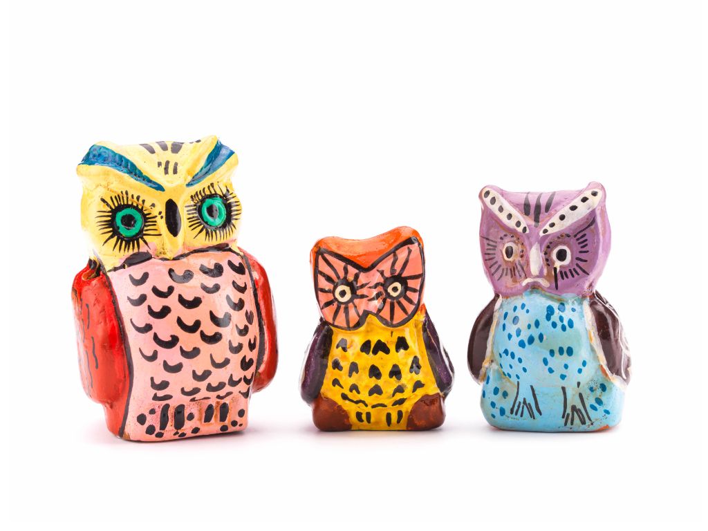 Drei mehrfarbige Eulenfiguren stehen nebeneinander. Links eine grössere Eule, in der Mitte eine kleine Eule, und rechts eine mittelgrosse Eule
