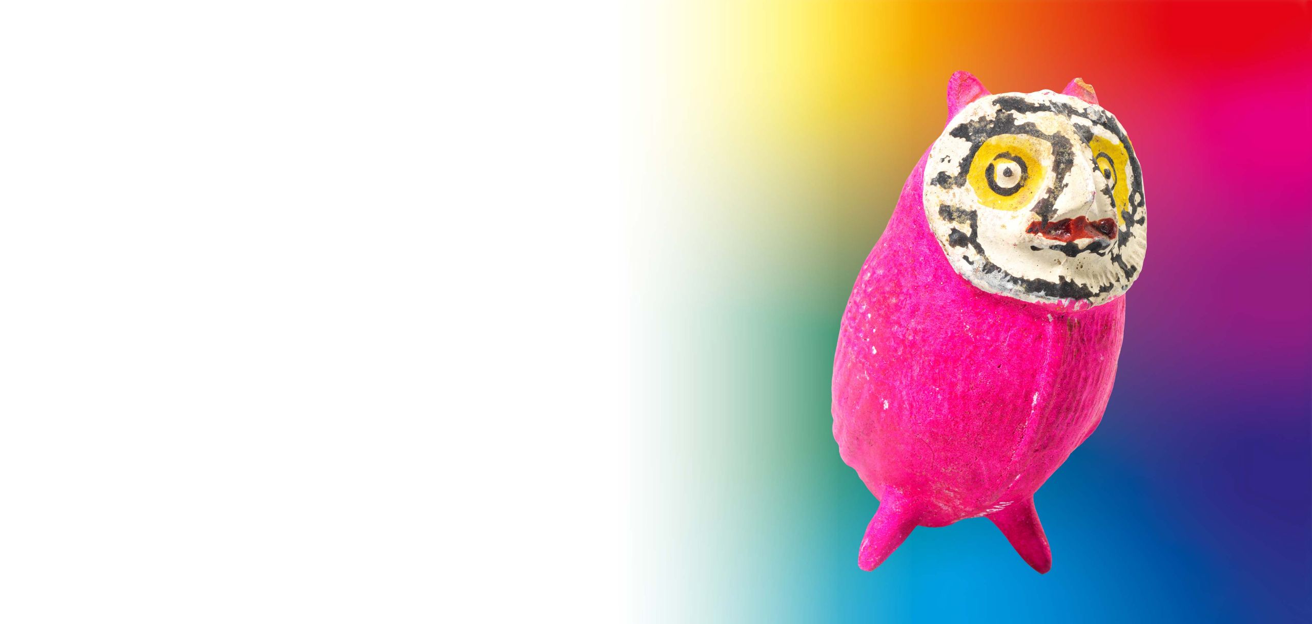Une chouette rose aux grands yeux se tient devant un arrière-plan coloré et flou