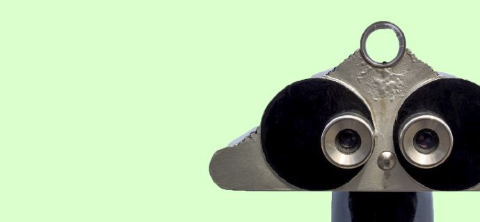 Ein silbernes, fernglasartiges Gerät blickt frontal auf einem hellgrünen Hintergrund